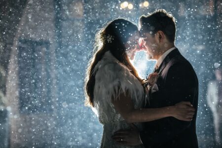 Bride and groom facing each other in rain at night - Picture by Rafe Abrook Photography