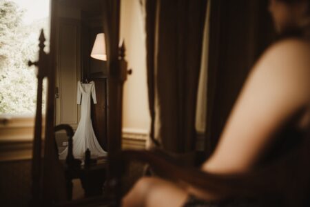 Bride sitting facing mirror showing reflection of her wedding dress - Picture by The Soulcase