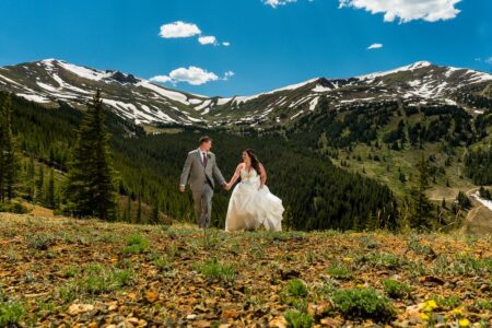 Bride and groom walking in front of stunning tree-covered mountain backdrop - Picture by Bergreen Photography