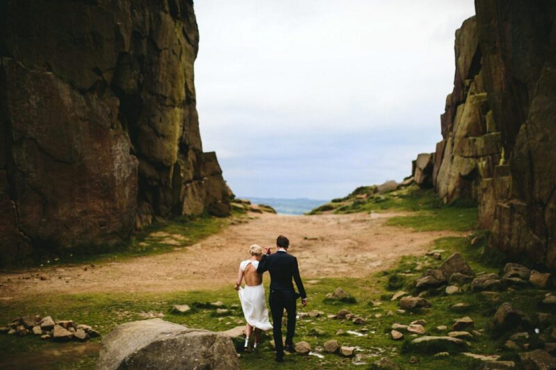 Bride and groom walking between two cliffs - Picture by Craig Williams Photography