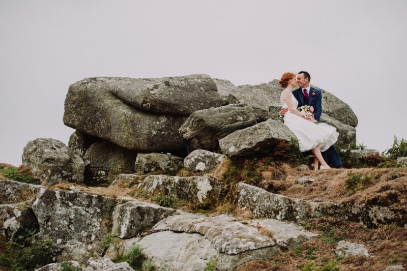 Bride and groom sitting on large rocks - Picture by Special Day Wedding Photos