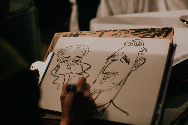 Caricaturist drawing guests at wedding