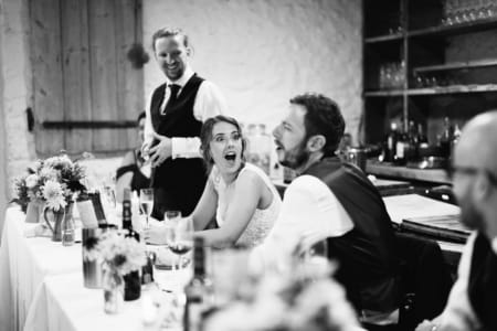 Bride looking at groom with shocked expression on her face during best man speech - Picture by Sam Gibson Photography