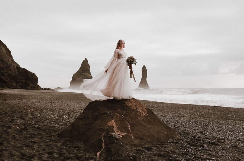 Bride standing on mound on beach - Picture by Chelsea Warren Photography